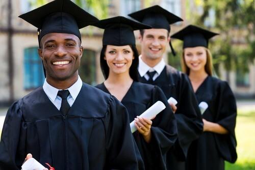 Four happy college graduates standing in a row. Photo courtesy of Shutterstock.
