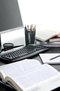 <p>Piles of books open with a computer. Working on a research paper. Photo courtesy of Shutterstock.</p>
