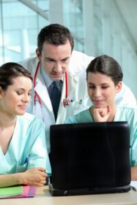 Three medical professionals watching a screen