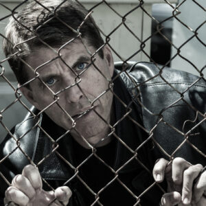 Prisoner behind chain link fence
