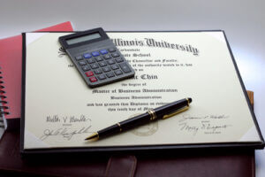 An MBA certificate with a pen and calculator on top of it