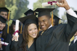 Graduates smiling and holding diplomas