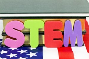 The word STEM in multiple colors placed on the American flag
