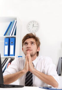 Businessman sitting in office praying
