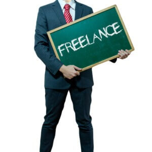 Businessman holding a chalkboard with the word Freelance on it