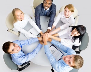 Business team looking above with hands piled together