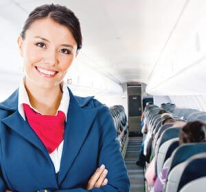 Smiling female flight attendant inside an airplane
