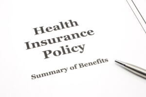 A health insurance policy with a pen for signing the papers