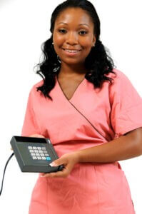 Female medical professional holding a credit card processing machine