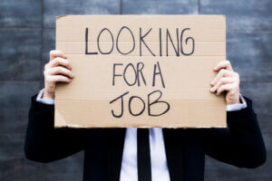 Young businessperson holding a sign looking for a job