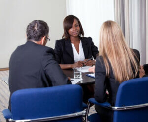 Group of managers interviewing female job candidate