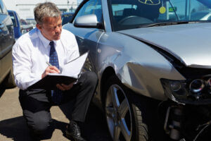 Loss adjuster inspecting car involved in an accident