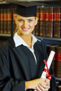 Smiling female law school graduate in university library, holding degree, diploma, or certificate