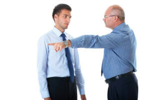 Junior worker getting fired by senior manager, pointing his hand and finger