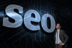The word seo and serious businessman with hands on hips in black and blue background