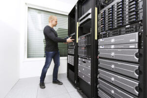 It engineer / consultant working and install / inserts a router / switch in a data rack.