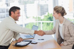 Woman shaking hands while having an interview in office