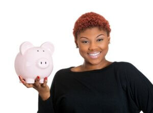 Closeup portrait of young woman holding her piggy bank friend in hand, isolate on white background. Positive emotion facial expression feelings. Smart wise saving paid financial decisions. 