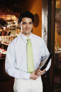 Portrait of waiter holding menus in restaurant 