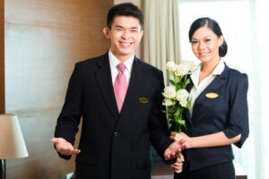 Hotel Manager or director and supervisor welcome arriving VIP guests with roses on arrival in luxury or grand hotel 