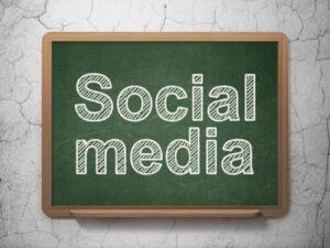 Social media concept: text Social Media on green chalkboard on grunge wall background, 3d render