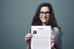 Young smiling cheerful woman holding her resume.