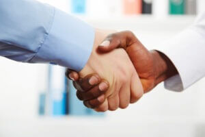 Businessmen shaking hands while in their office