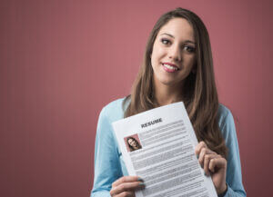 young smiling woman holding her resume and applying for a job